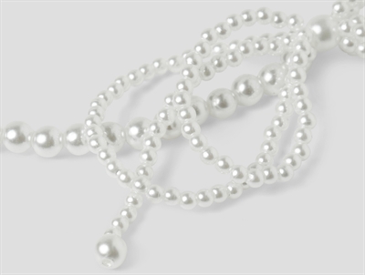 Nærbillede af smykkesæt fra Name It i hvid med perler og sløjfe